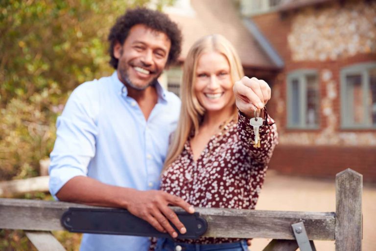 portrait-of-excited-couple-by-gate-holding-house-k-2023-11-27-05-22-35-utc
